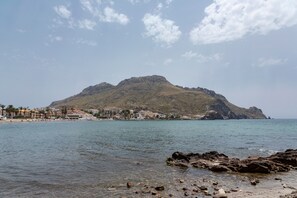 Une ville côtière caractérisée par une colline imposante, une eau limpide et une côte rocheuse.