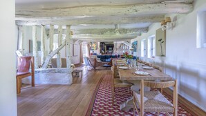 A spacious dining area with a long wooden table set for six, surrounded by wicker chairs. - Maison Le Clos Longlais - Welkeys (Grangues)