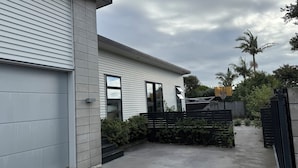 Une maison moderne à deux étages, dotée d’un garage, d’une allée en béton et d’une cour arrière clôturée.
