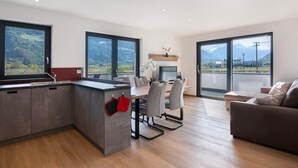 Una cucina moderna con zona pranzo, ampie finestre e vista sulle montagne.