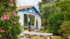 Une maison avec un patio, une table à manger et des chaises.