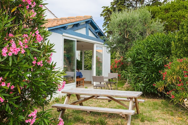 Una casa con un patio, una mesa de comedor y sillas.