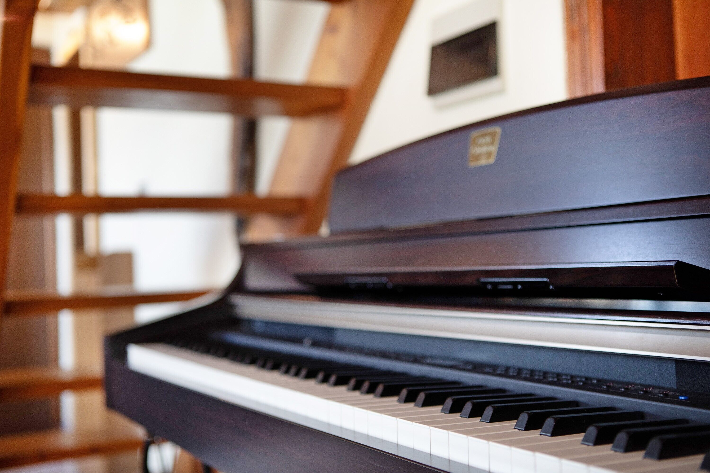 Ett piano med träfanér och en logotyp på sidan.