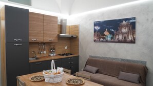 A modern kitchen with dark cabinets, a wooden countertop, and a dining table with placemats.