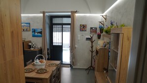 A compact kitchen with a dining table, chairs, and a wooden cabinet.