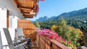 Un balcón de madera con vistas a un paisaje montañoso.