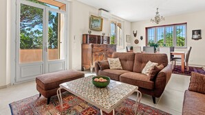 A spacious living area with a sofa, ottoman, and a coffee table with a bowl. - Villa 'Chantegrive' with sea view, Wi-Fi and air conditioning (Roquebrune-sur-Argens)