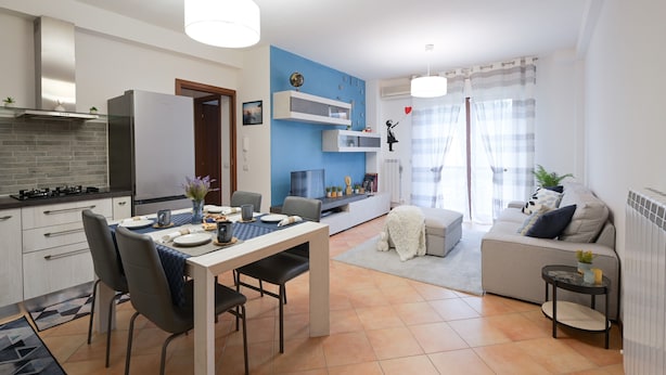 Eine moderne Wohnung mit Küche, Essbereich, Wohnzimmer und Balkon.