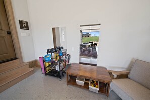 A room with a wooden table, a gray sofa, and a bike storage unit.