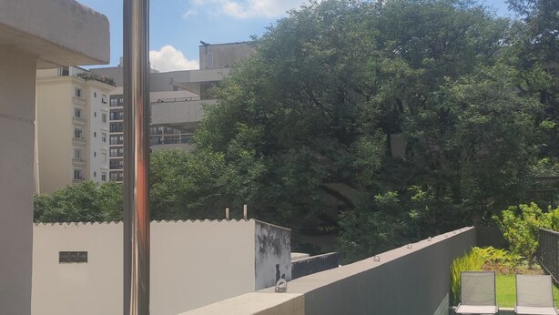 A modern outdoor pool area with a built-in shower, surrounded by a wooden deck and a pool with clear blue water. - Charming studio next to PUC-SP, Allianz Parque and Pacaembu (Perdizes São Paulo)