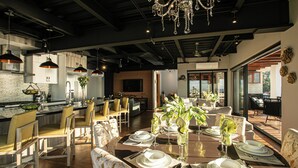 A modern dining area with a large table set for six, surrounded by chairs. - First Class Penthouse 3 bed 3 bath + Dipping Pool - CPH2 (Puerto Vallarta)