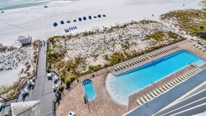 A beachside resort with a swimming pool, sun loungers, and a beach area with umbrellas. - 1002 Oceanfront Pelican Beach Resort Amazing Location Multiple Pools & Hot Tubs (Destin)
