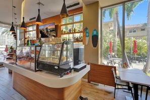 Un café con mostrador, vitrina y zona de estar.