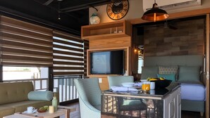 Una sala acogedora con sofá, mesa de comedor, televisor y encimera de cocina.