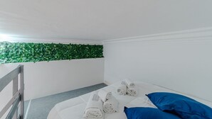 A small, clean room with a bed, pillows, and neatly folded towels. - GuestHost - Comfortable Studio Apartment GIOVE- Torino (Torino)