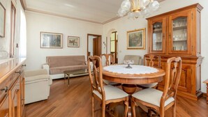 A dining area with a round wooden table, chairs, a chandelier, a sofa, and a cabinet with glass doors. - GuestHost - Wonderful apartment of about 80 square meters, able to accommodate 5 people, located on the first floor of a villa without a lift (with internal and external steps).The property is located in the heart of Venice Mestre, in a quiet and well-se (Venice)