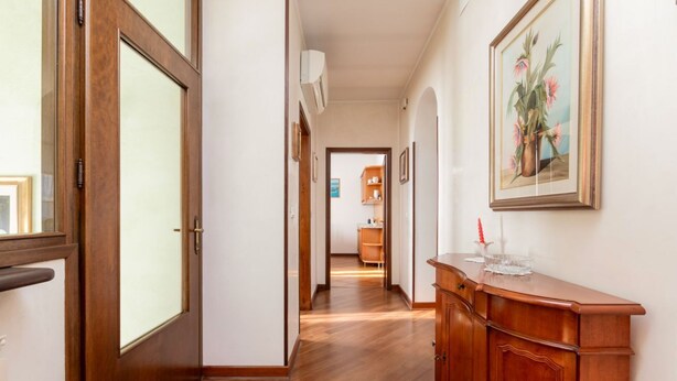 A hallway with wooden flooring, a wooden door, a cabinet, and a framed painting on the wall. - GuestHost - Wonderful apartment of about 80 square meters, able to accommodate 5 people, located on the first floor of a villa without a lift (with internal and external steps).The property is located in the heart of Venice Mestre, in a quiet and well-se (Venice)