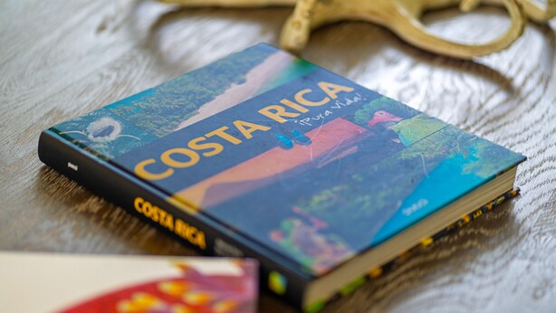 A book titled 'Costa Rica' with a colorful cover, placed on a wooden surface.