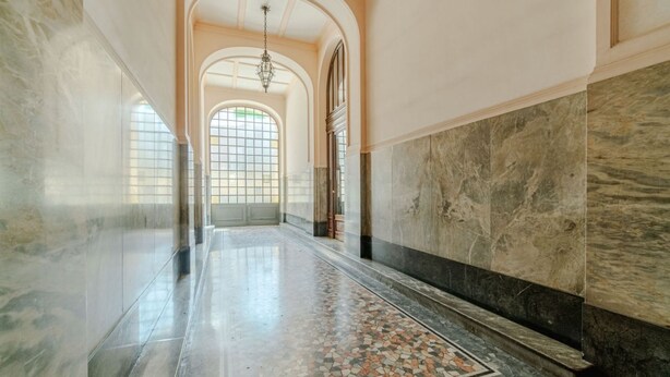 A hallway with marble walls, a tiled floor, and a chandelier. - GuestHost - Comfortable Studio Apartment VENERE - Torino (Torino)