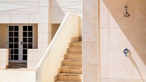 A building with a staircase leading to a door with glass panels, a tiled wall with a showerhead, and a chair outside. - Poolside Studio Near Dover & Turtle Beach w/ Pool (Oistins)