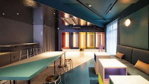 A modern interior with a bar area, seating, and a pool table.