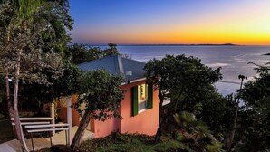 A house with a view of the sea at sunset.