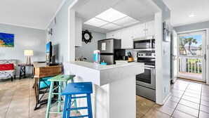 A modern kitchen with white cabinets, stainless steel appliances, and a central island. - Sandpiper Cover 2031 near beach sleeps 4 (Destin)