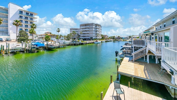 A marina with boats docked, a wooden dock, and buildings in the background. - Destin Harbor Views & Access to Boat Dock! CP6 (Destin)