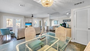A modern living room with a glass dining table, wicker chairs, a ceiling fan, and a coffee bar. - Destin Harbor Views & Access to Boat Dock! CP6 (Destin)