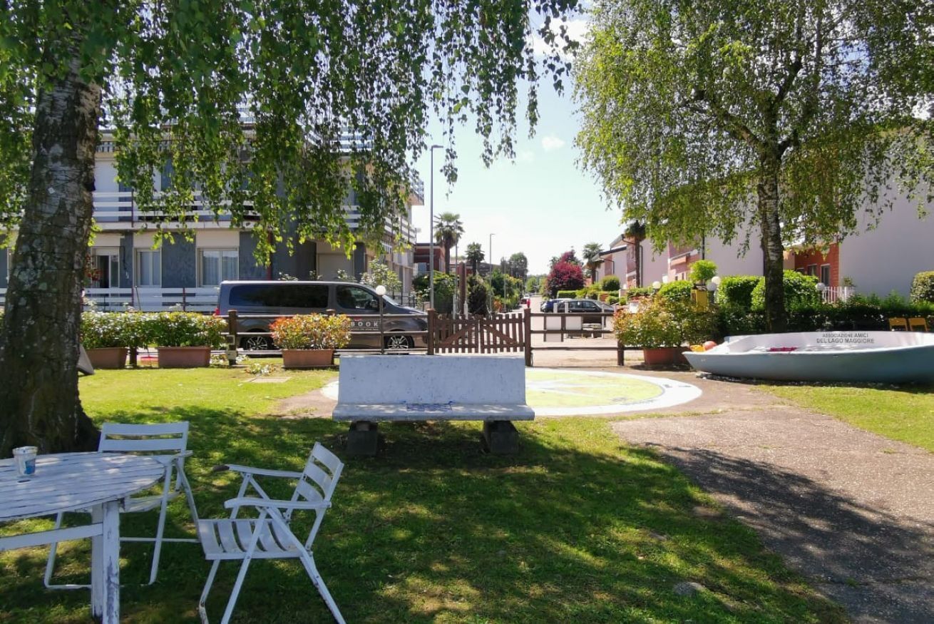 A park area with a white bench, picnic tables, and a boat.