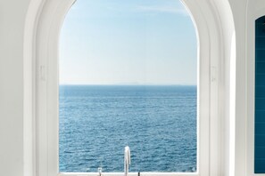 A view from a window with a white frame, overlooking a body of water.