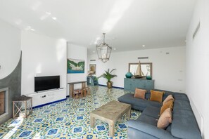 A living room with a television, sofa, coffee table, and patterned floor.