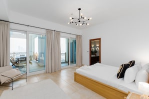 Un dormitorio moderno con una cama grande, un balcón con vistas y una lámpara en el techo.
