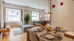 Ein modernes Wohnzimmer mit einer Couch, einem Esstisch und einer Frühstücksecke.