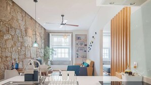 Una cocina moderna con una pared de acento de piedra, un ventilador de techo y una zona de comedor con vistas.