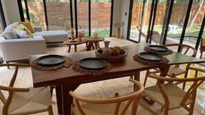 A dining area with a wooden table set for four, surrounded by wicker chairs. - Beautiful house - Riviera Maya. Mayakoba Country Club (Playa del Carmen)