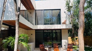 A modern house with a pool, two lounge chairs, and a dining table. - Beautiful house - Riviera Maya. Mayakoba Country Club (Playa del Carmen)