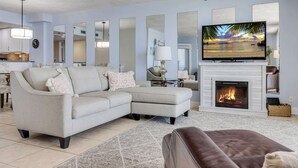 Una sala de estar con chimenea, televisión y sofá.
