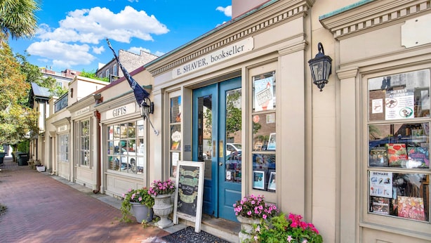 Une librairie avec une porte bleue et une enseigne sur laquelle on peut lire : « E. Shaver, libraire ».