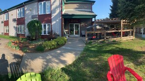 A two-story building with a reception area, a covered outdoor seating area, and a parking lot.