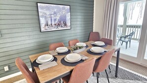 Comedor con mesa de madera dispuesta para seis personas, rodeada por seis sillas.
