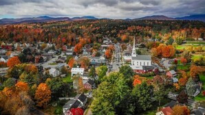 A town with a prominent church, surrounded by autumn-colored trees and residential houses. - Centrally located 2BR condo, Hot Tub&Indoor Pool (Stowe)
