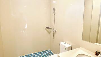 Une salle de bain avec des toilettes, une douche et un lavabo.