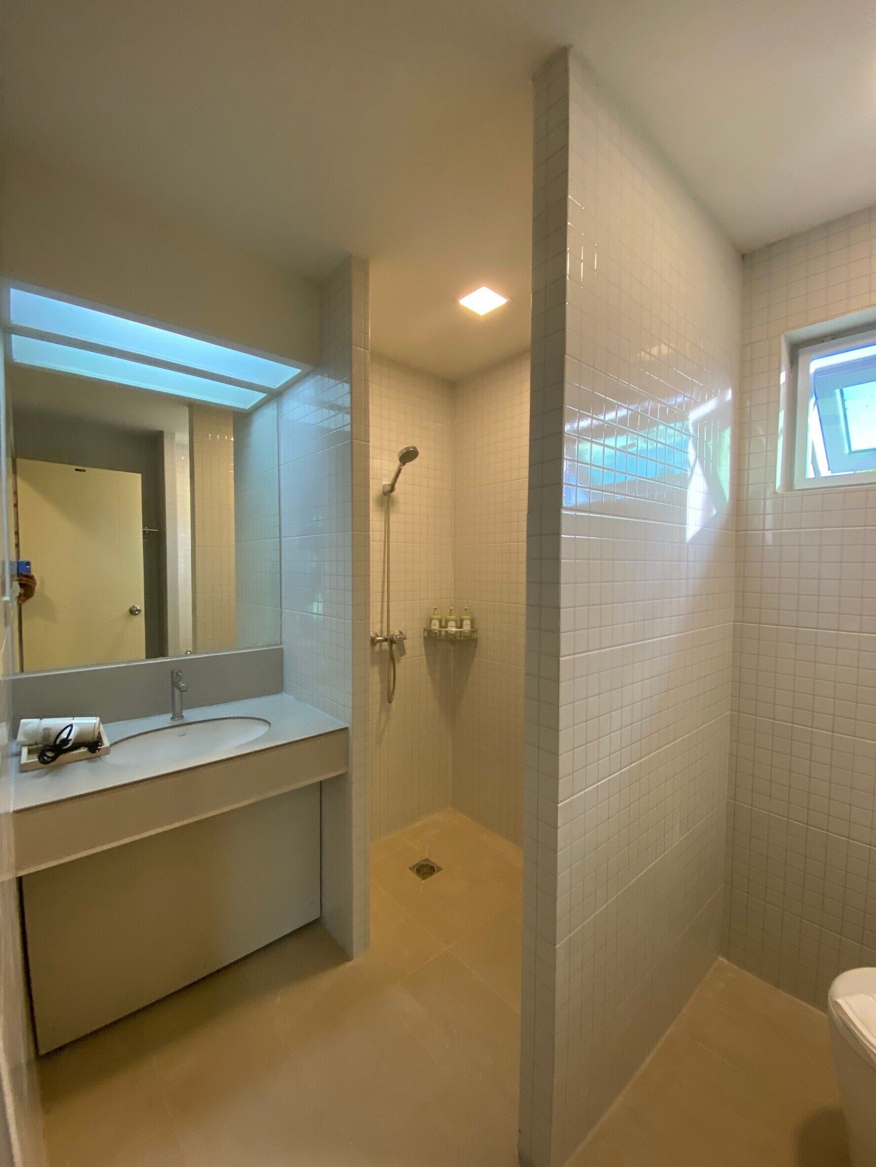 Ein Badezimmer mit Dusche, Waschbecken und Toilette.