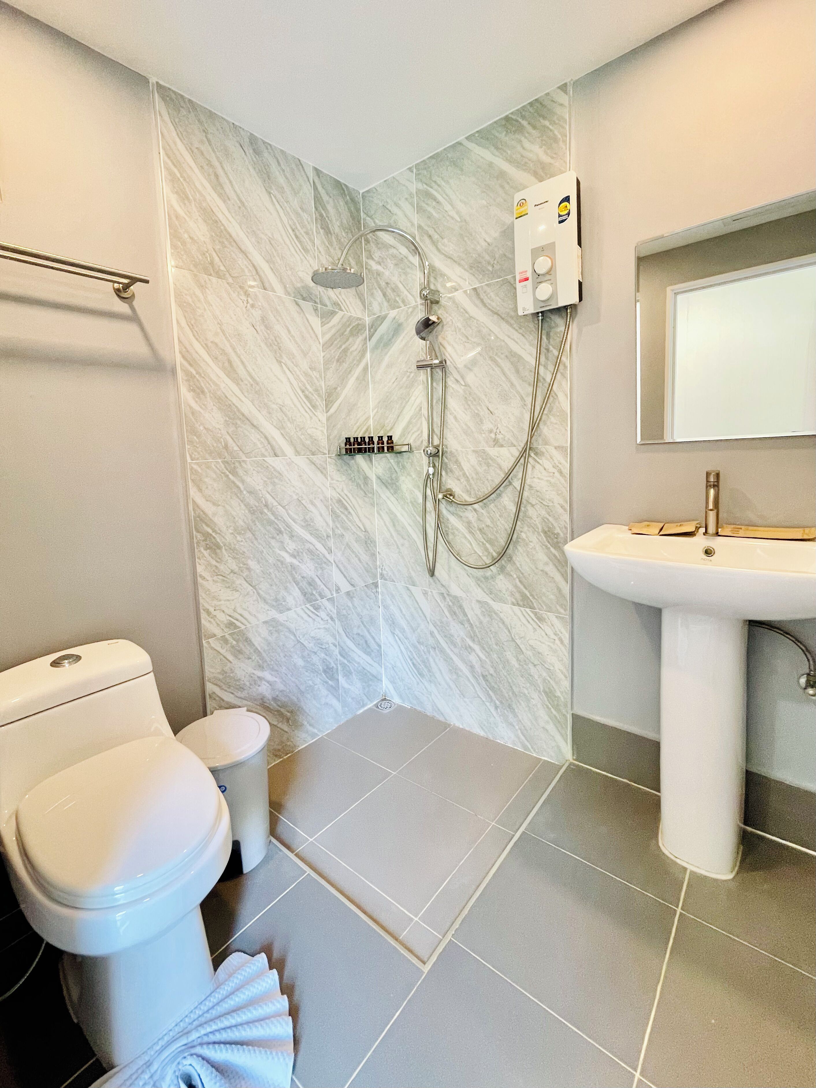 A bathroom with a toilet, bidet, and shower.