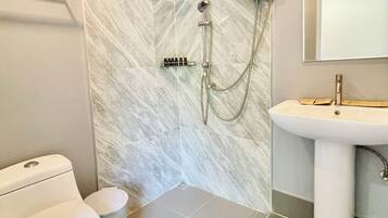 A bathroom with a toilet, bidet, and shower.