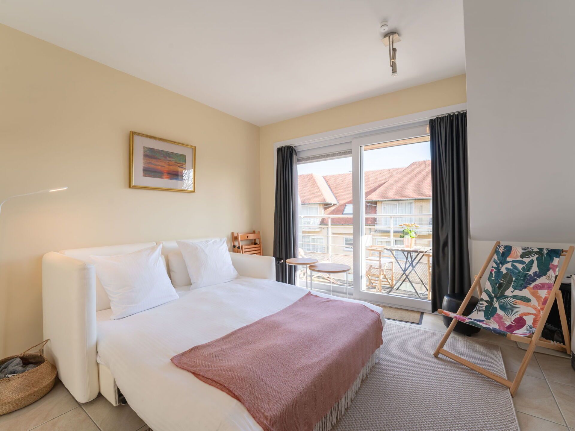 Una camera d'albergo con un letto, un tavolino, una sedia e vista sull'esterno.