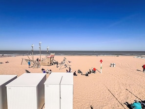 A beach with a wooden structure, possibly a lifeguard station, and a clear view of the ocean.
