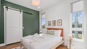 A bedroom with a bed, a wardrobe, a window, and a wall-mounted shelf. - Gallatin Retreat-Rooftop- Full Gym -East Nashville (Nashville)