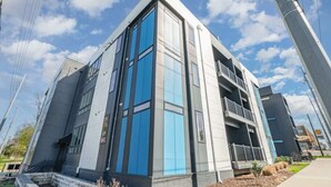 A modern building with large windows, a balcony, and a clear sky. - Gallatin Retreat-Rooftop- Full Gym -East Nashville (Nashville)